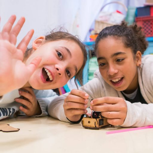Duas crianças montando um projeto TheInventors