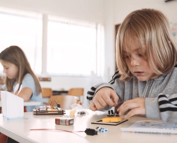 Criança a montar projeto de electrónica TheInventors